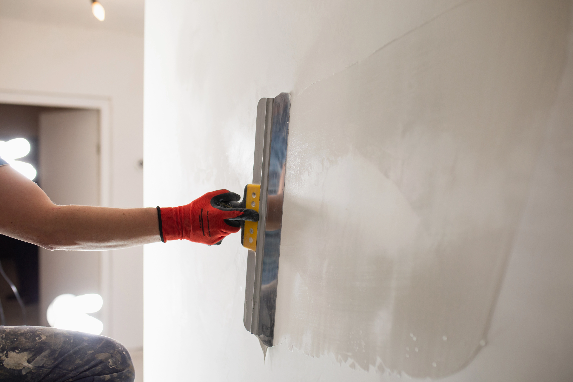 contractor smoothing drywall repair with trowel